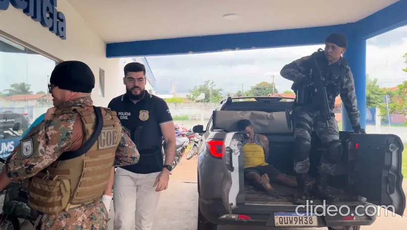 Delegado David ladeado pelos policiais militares e no fundo o preso Marcelito